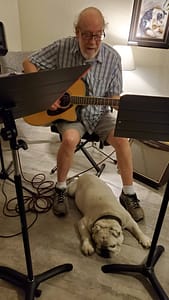 Psul playing guitar, BeauBo at his feet.